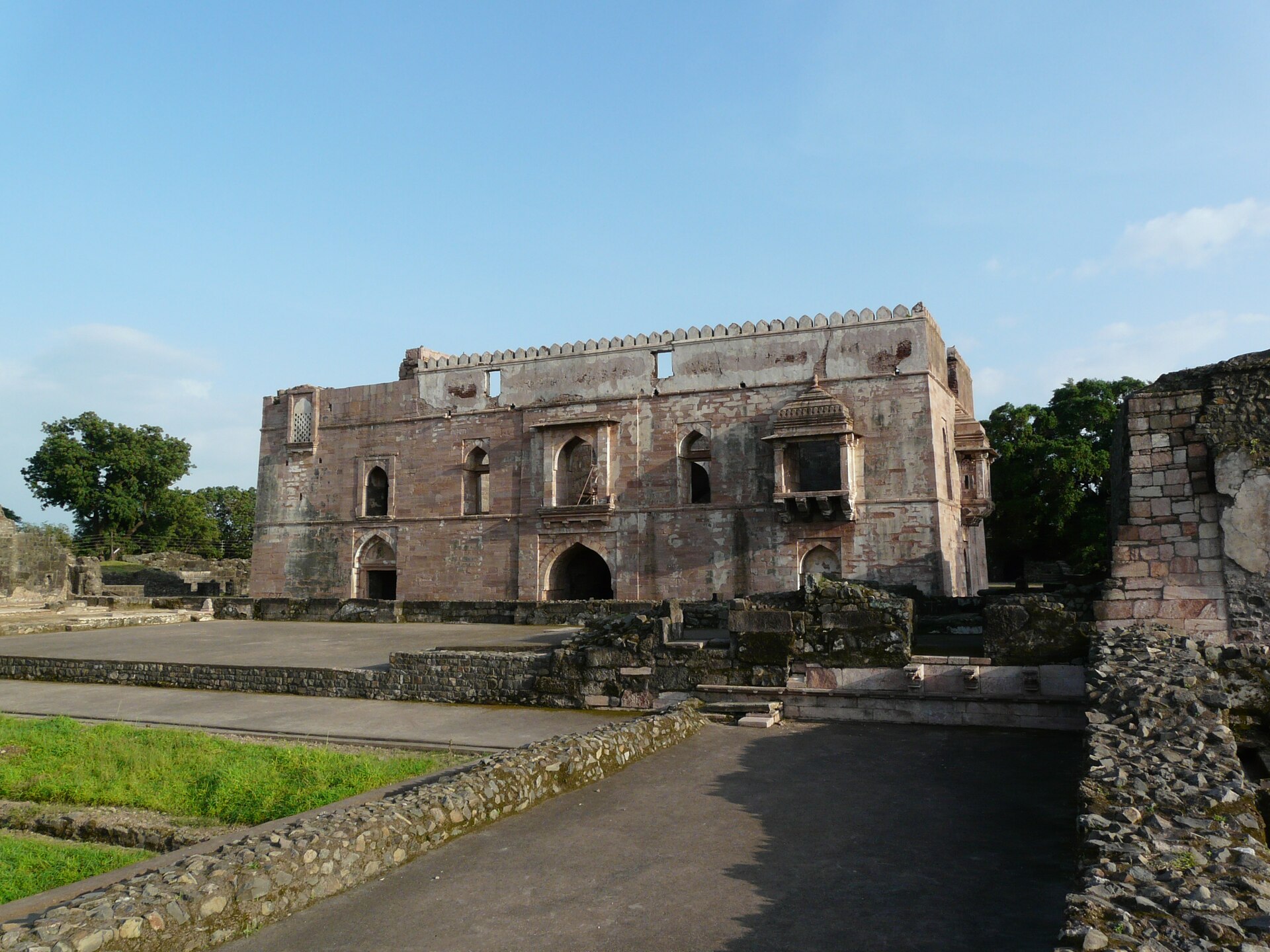 Jahaz Mahal (Ship Palace) at Mandu surrounded by monsoon greenery under a dramatic sky